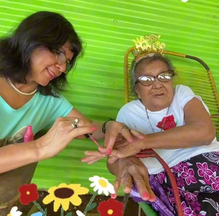 Amalia Jarquín laughs with an elderly woman from the community