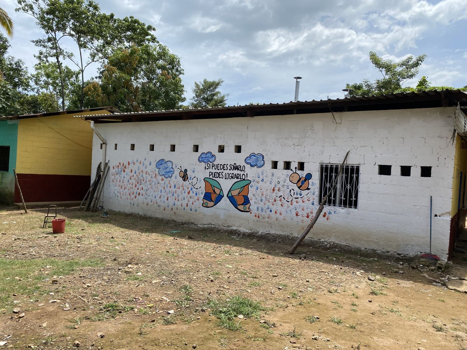 Butterfly, bee and handprint mural on a classroom wall with the Spanish motto “If you can dream it, you can do it!”