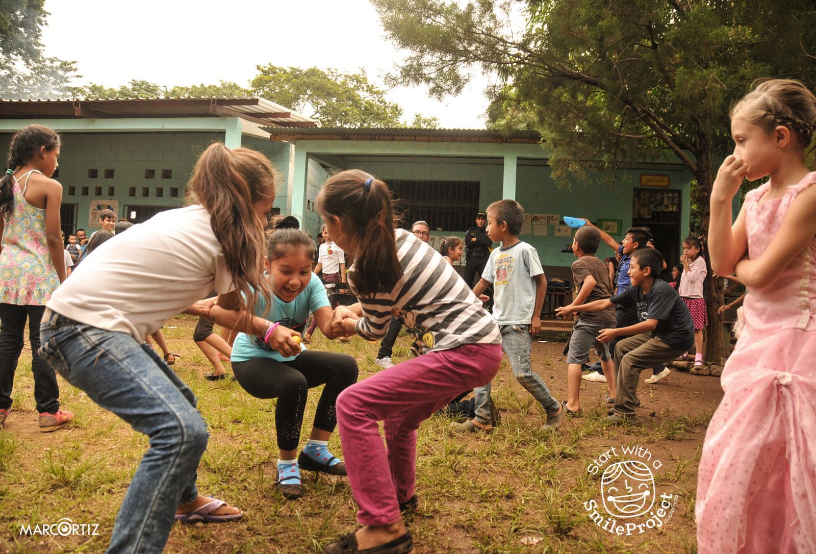 Children play a pairs game in the dirt schoolyard during Children’s Day in Las Delicias del Jobo