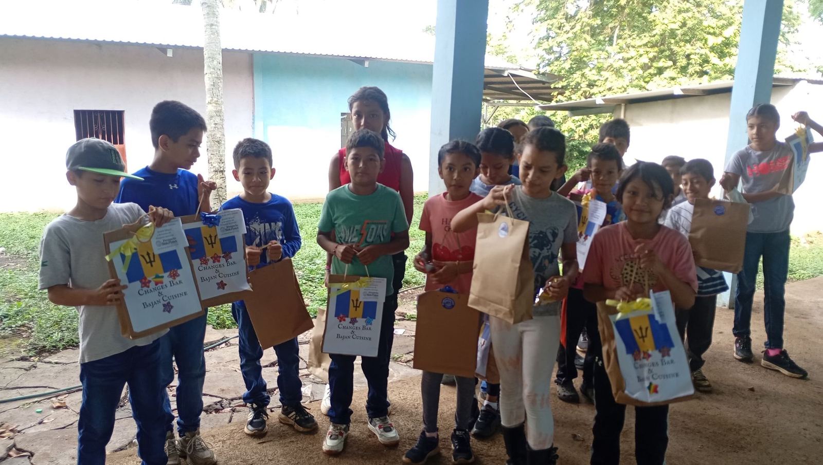 Children of the Los Lotes school hold up the bags of school supplies they received